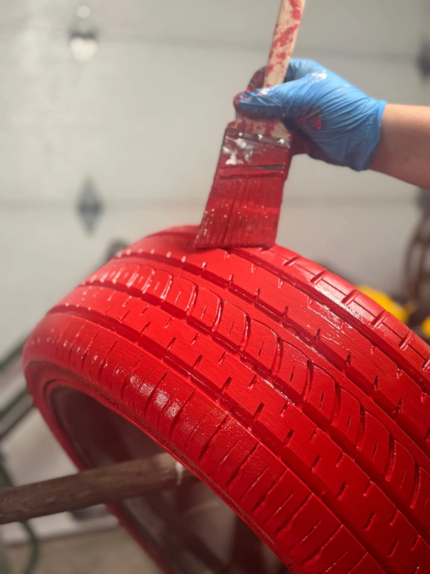 Pneu peint en rouge au pinceau pendant la fabrication d’un décor