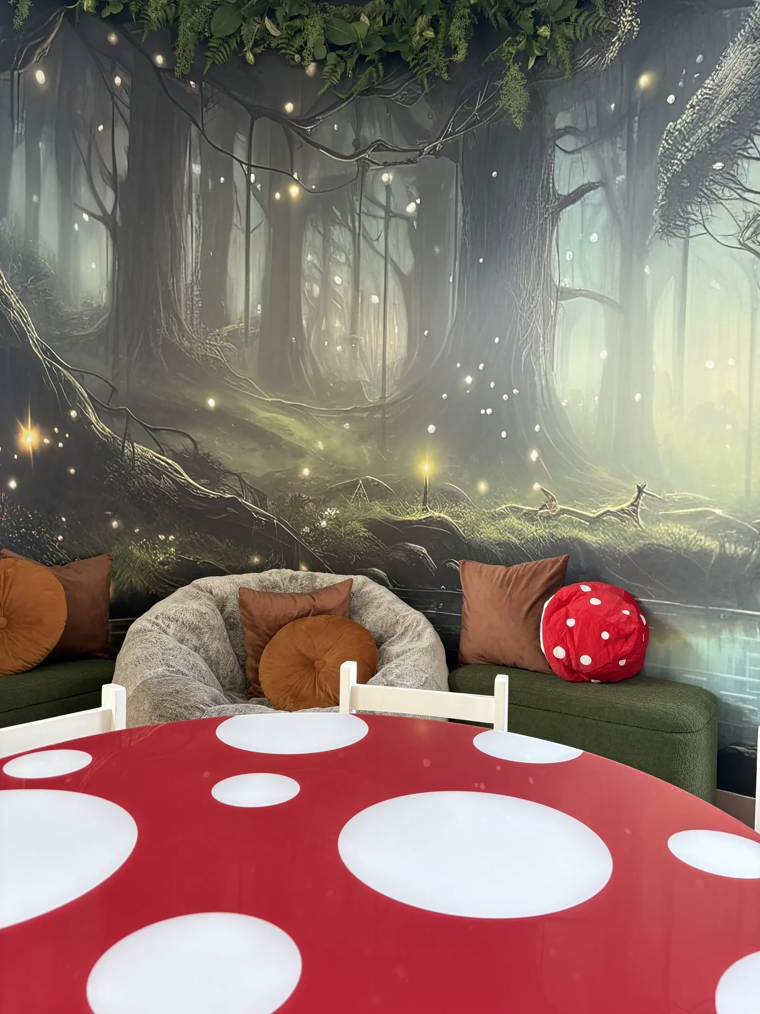Coin lecture pour enfants avec murale de forêt enchantée et table en champignon rouge à pois blancs
