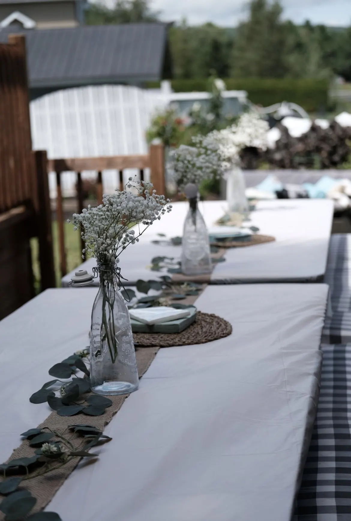 Longue table de fête prénatale avec vases de gypsophile et chemin de table naturel