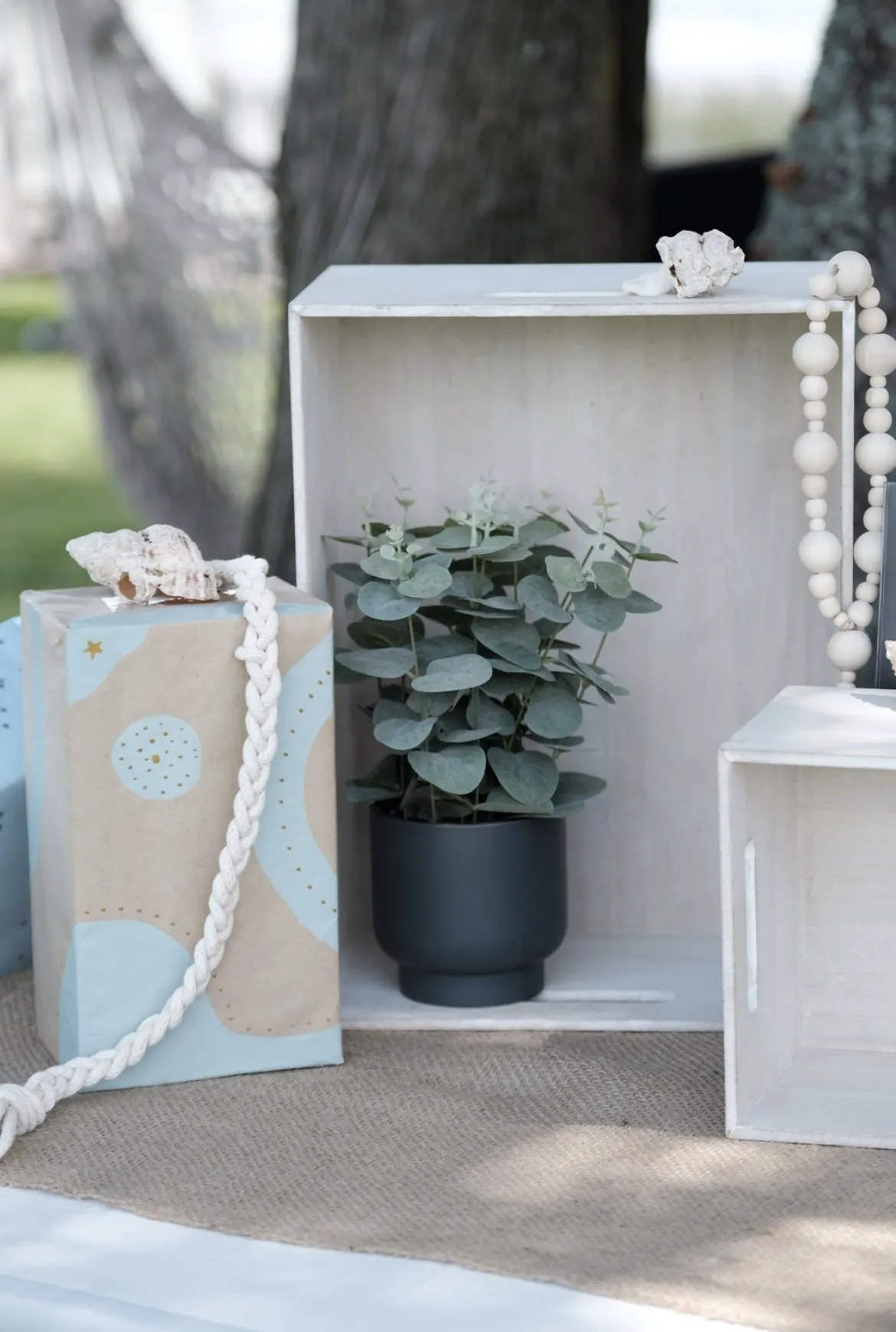 Caisses en bois blanchi, plante et cordage marin en décor de fête prénatale