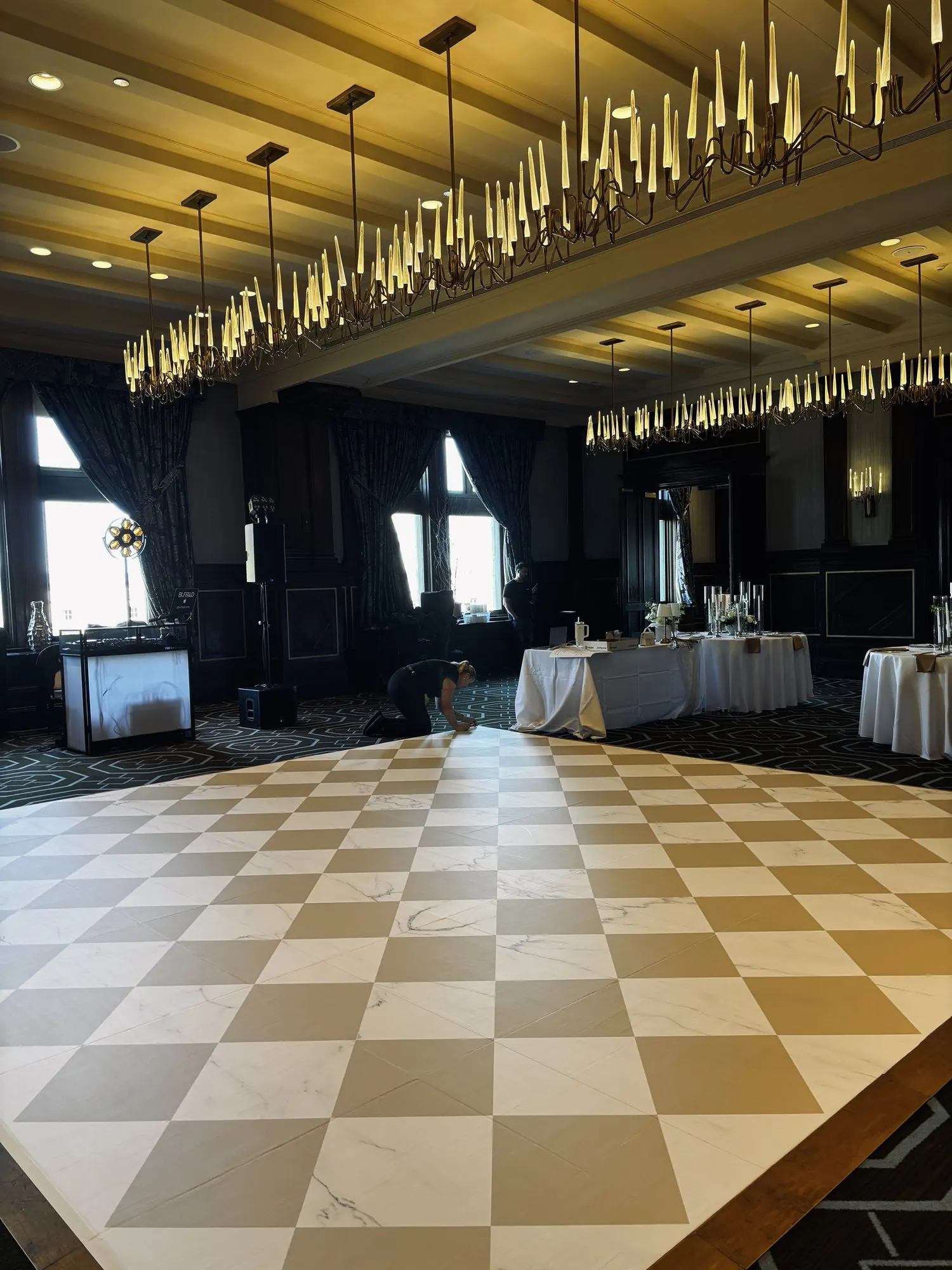 Plancher en damier effet marbre achevé sous les lustres de la salle de réception