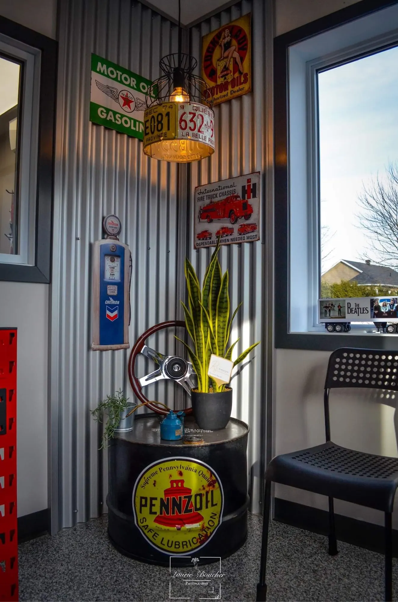 Coin d’attente façon station-service : tôle ondulée, plaques rétro et baril Pennzoil