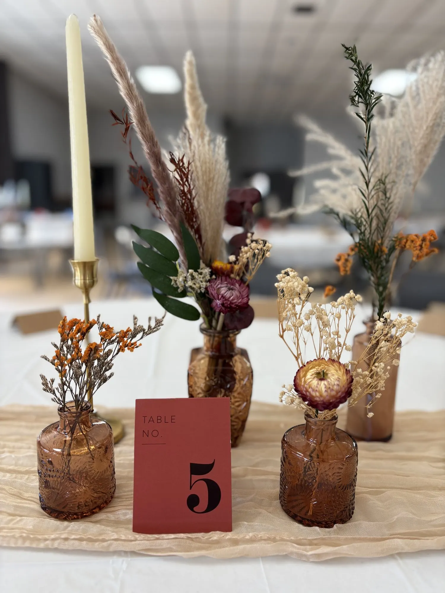 Centre de table avec vases ambrés et fleurs séchées