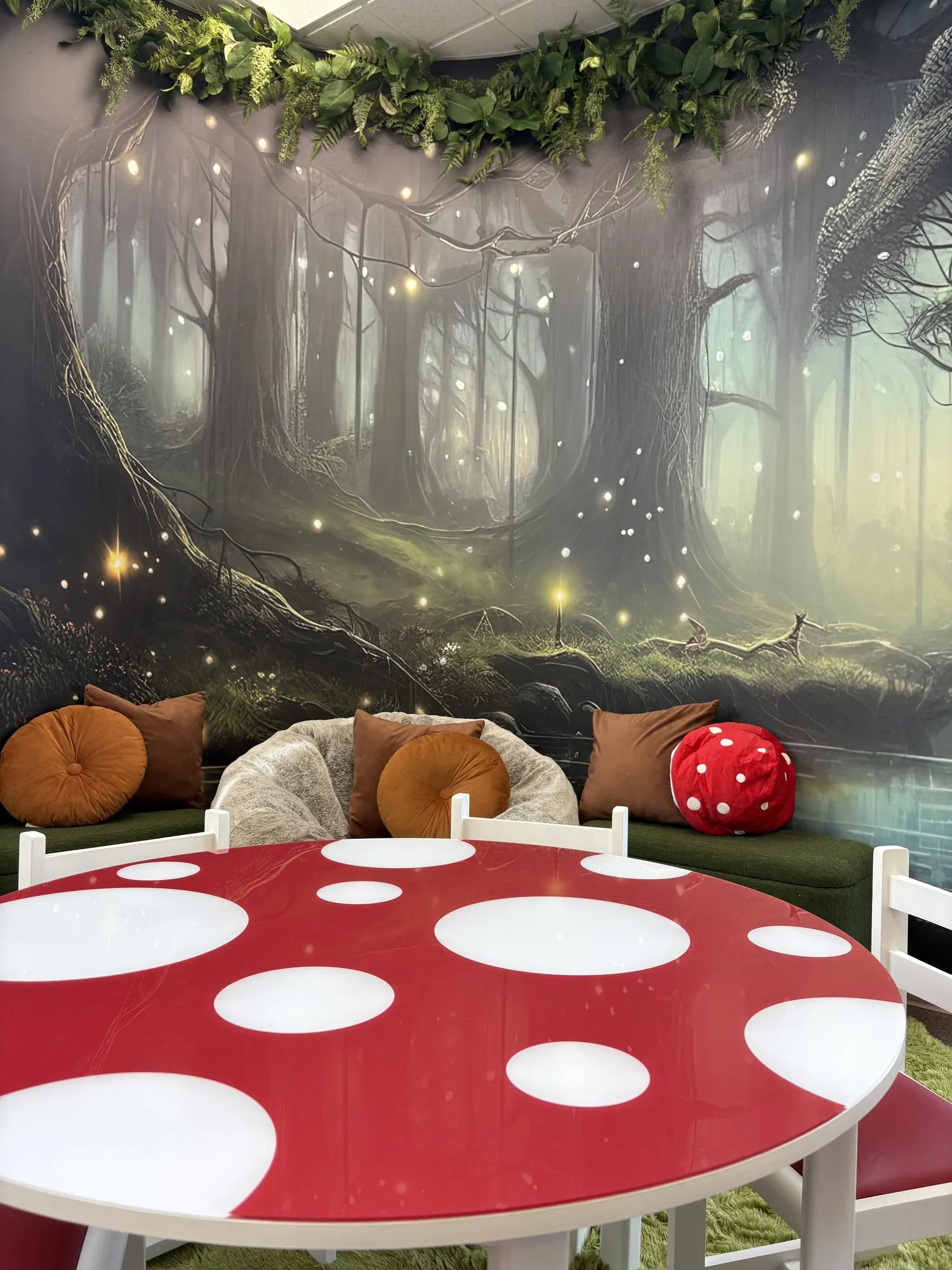 Coin lecture forêt enchantée avec murale de forêt, coussins et table champignon rouge à pois blancs
