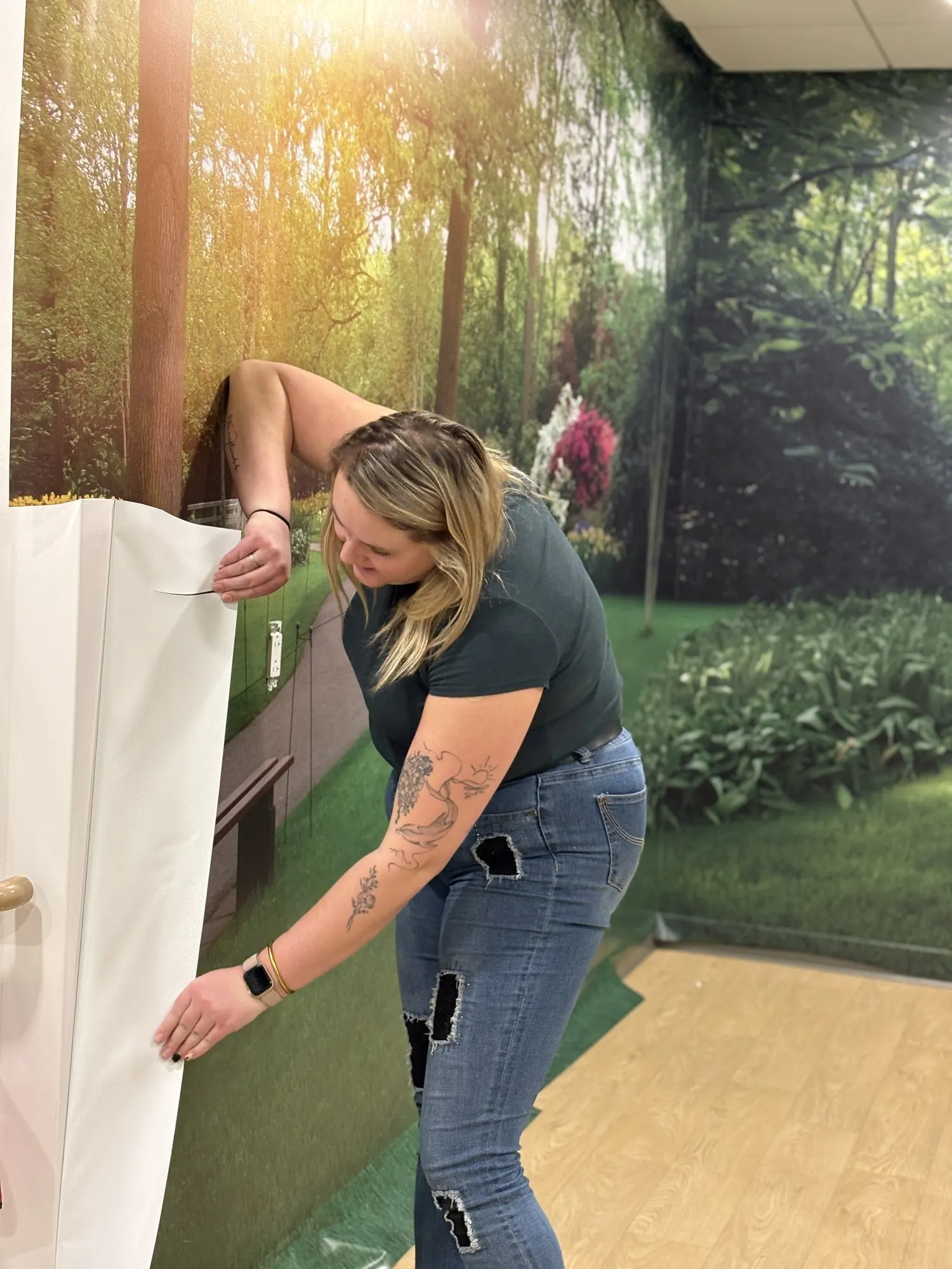 Esther Labrecque en train de poser une murale de vinyle
